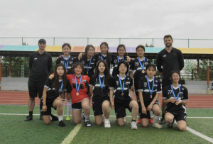 The varsity team celebrates with their well-deserved bronze medals hanging around their necks as their KISAC journey comes to a close. With renewed determination, they set their sights on an even stronger finish next time. 